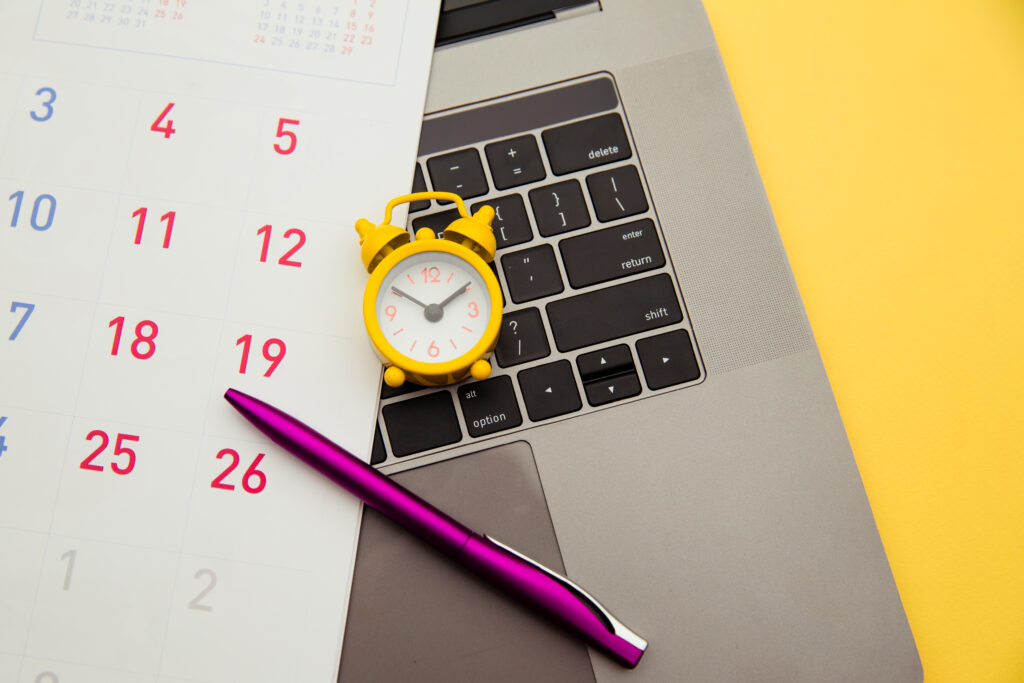 laptop alarm clock monthly calendar yellow background time running away